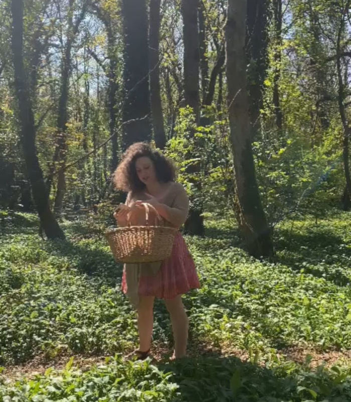 profile image of Naoise Ni Gealbhain in the woods with a foraging basket
